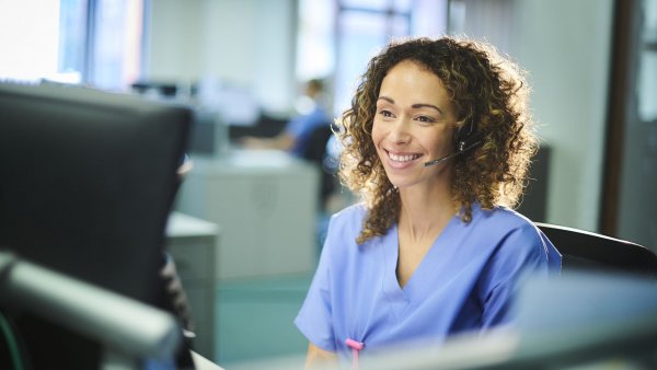 nurse looking at the computer with headphones on