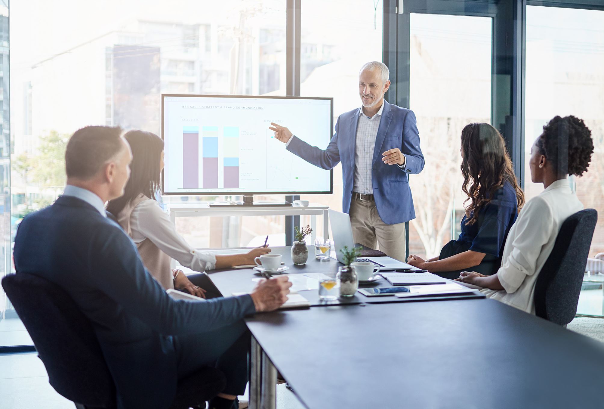 people having a meeting with graphs on the screen