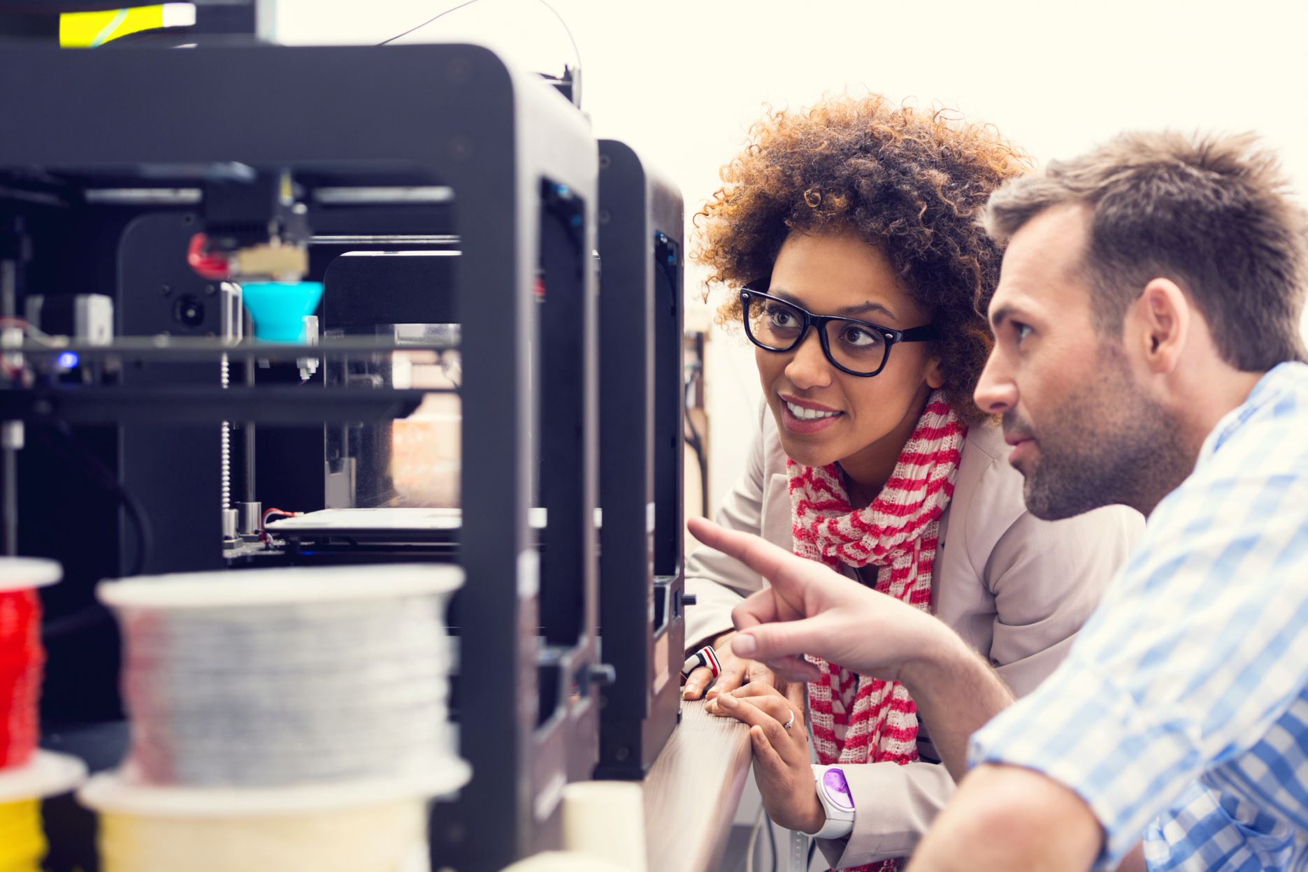 two people looking at a machine and talking