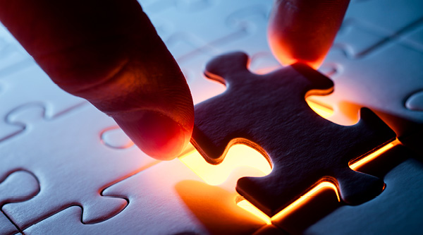 a person adding in a puzzle piece