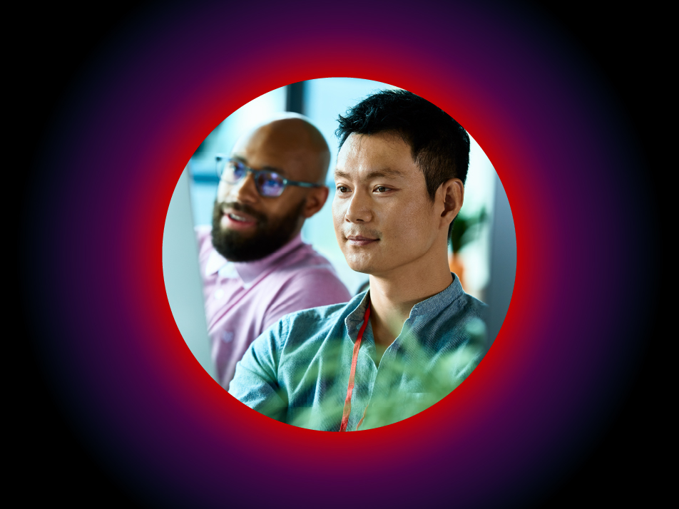 Two multicloud experts looking at a monitor to assess a current state of an IT infrastructure