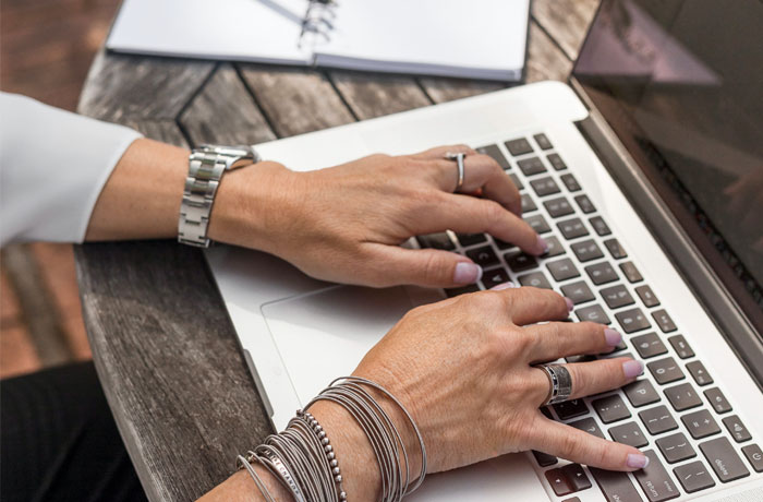 person's hands on laptop keyboard