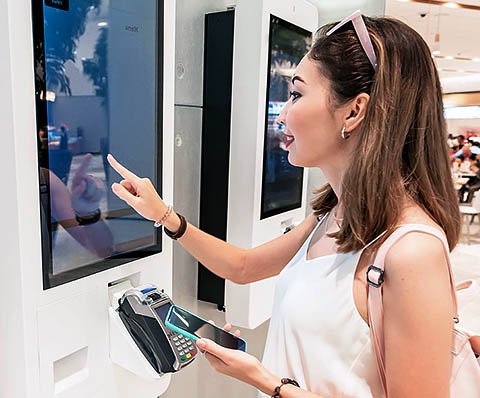 woman making a payment through a screen
