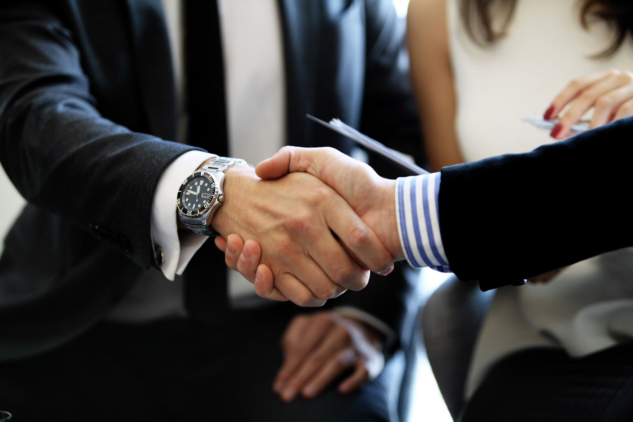 two people in suits shaking hands