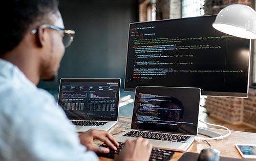 men looking at multiple screens with codes
