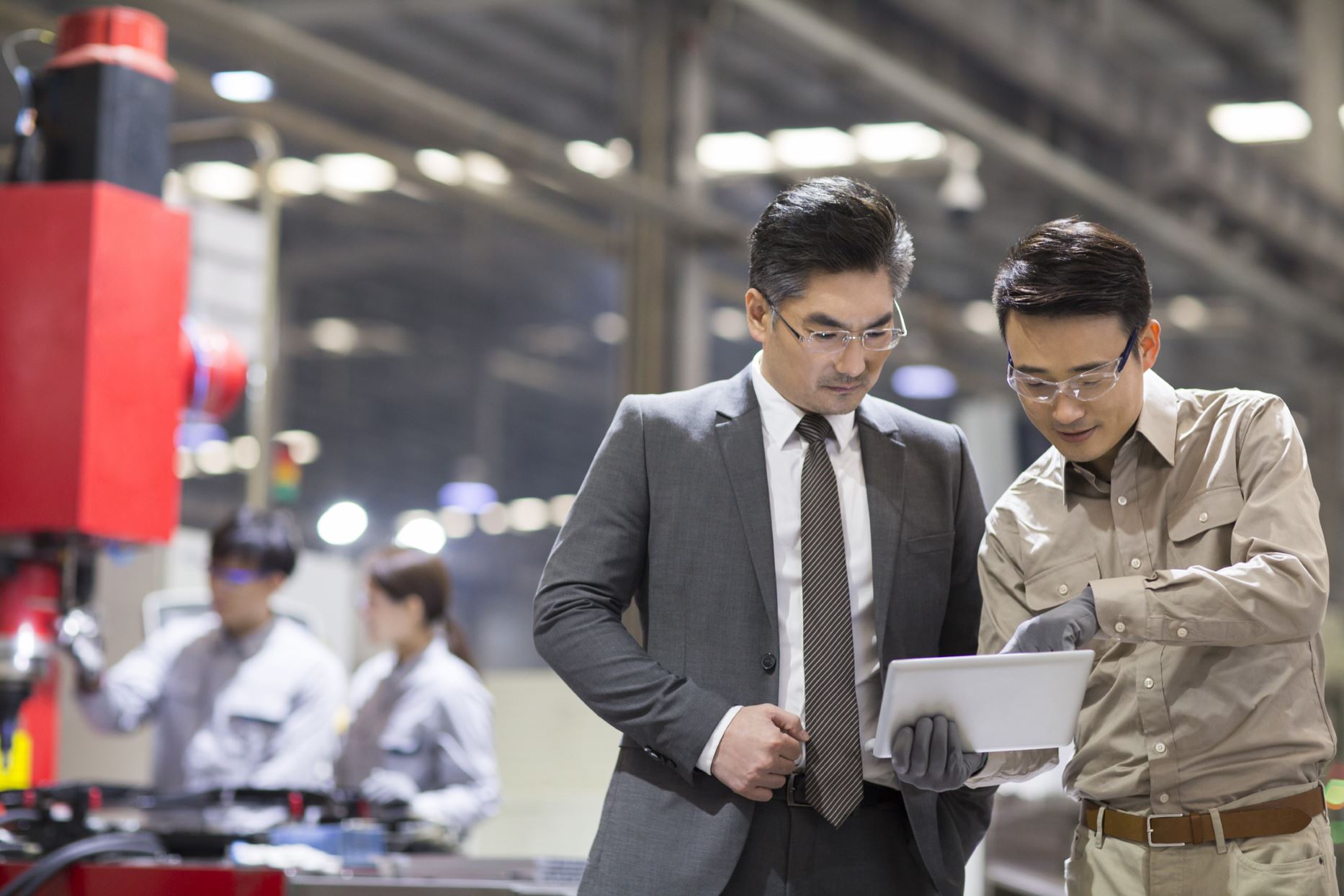 two people looking at the tablet in a factory