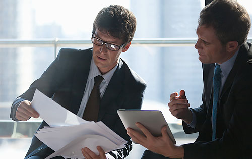 two people looking at papers