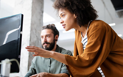 two people looking at a screen and talking