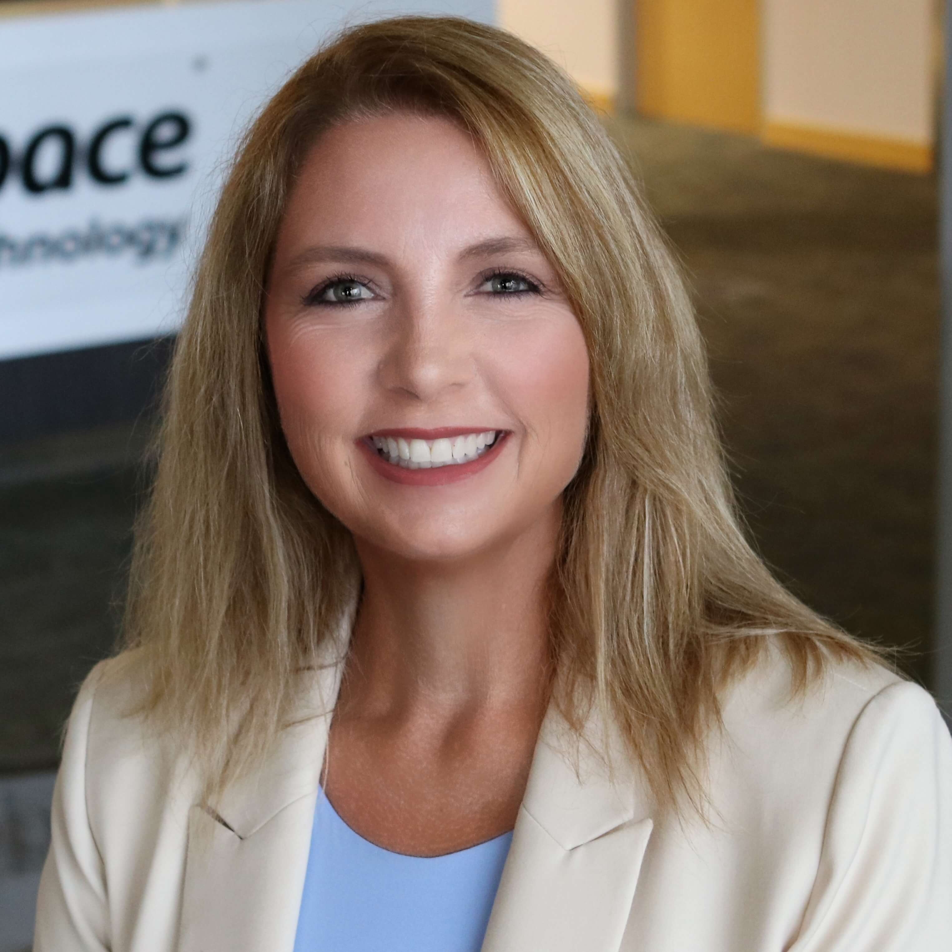 A woman in white suit smiling for picture