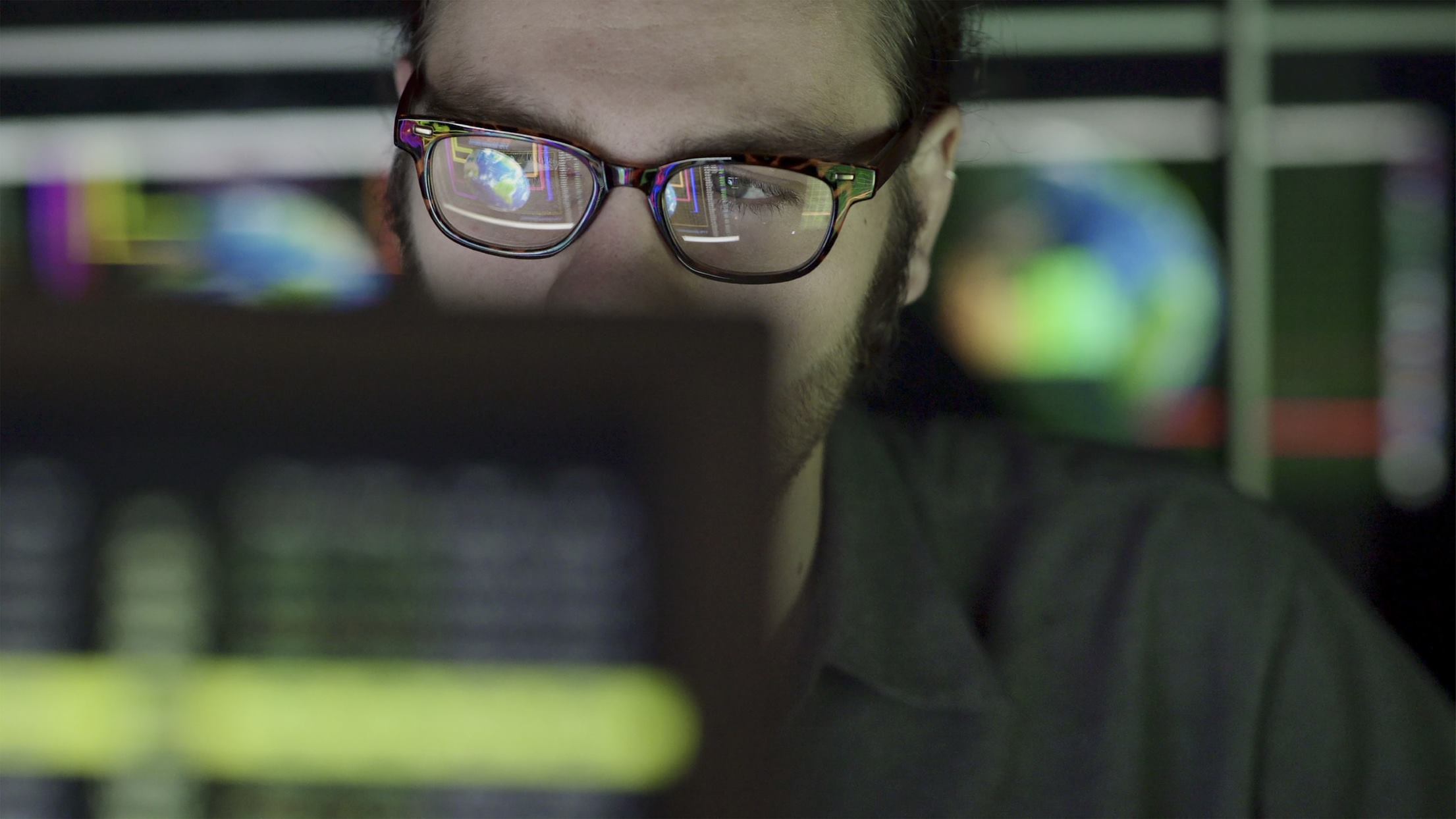 person with glasses looking at a computer