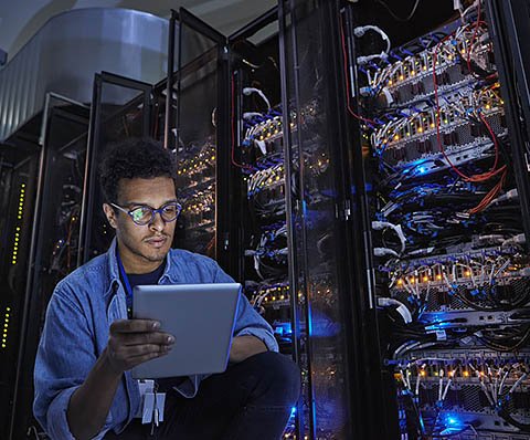 man working on a tablet in front of a database