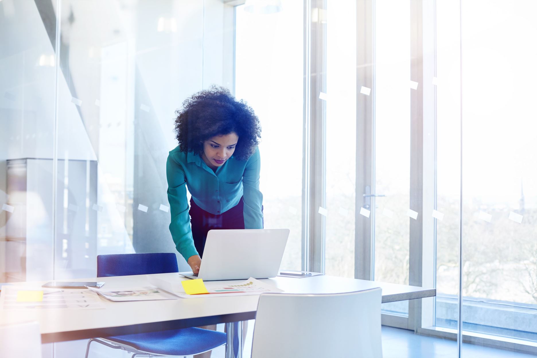 woman working on a laptop in a white room