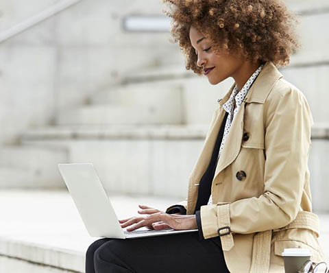 woman in a trench coat with a laptop