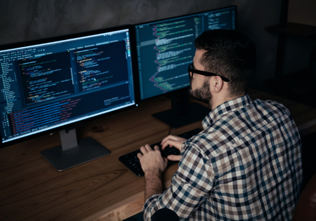 A man with glasses looking at a computer screen