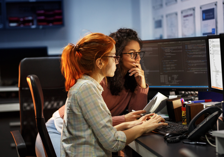 Two women with glasses looking at a screen