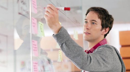 A man writing on a whiteboard