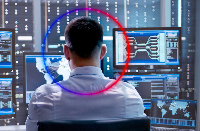 person working in front of multiple screens