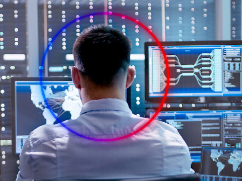 person working in front of multiple screens