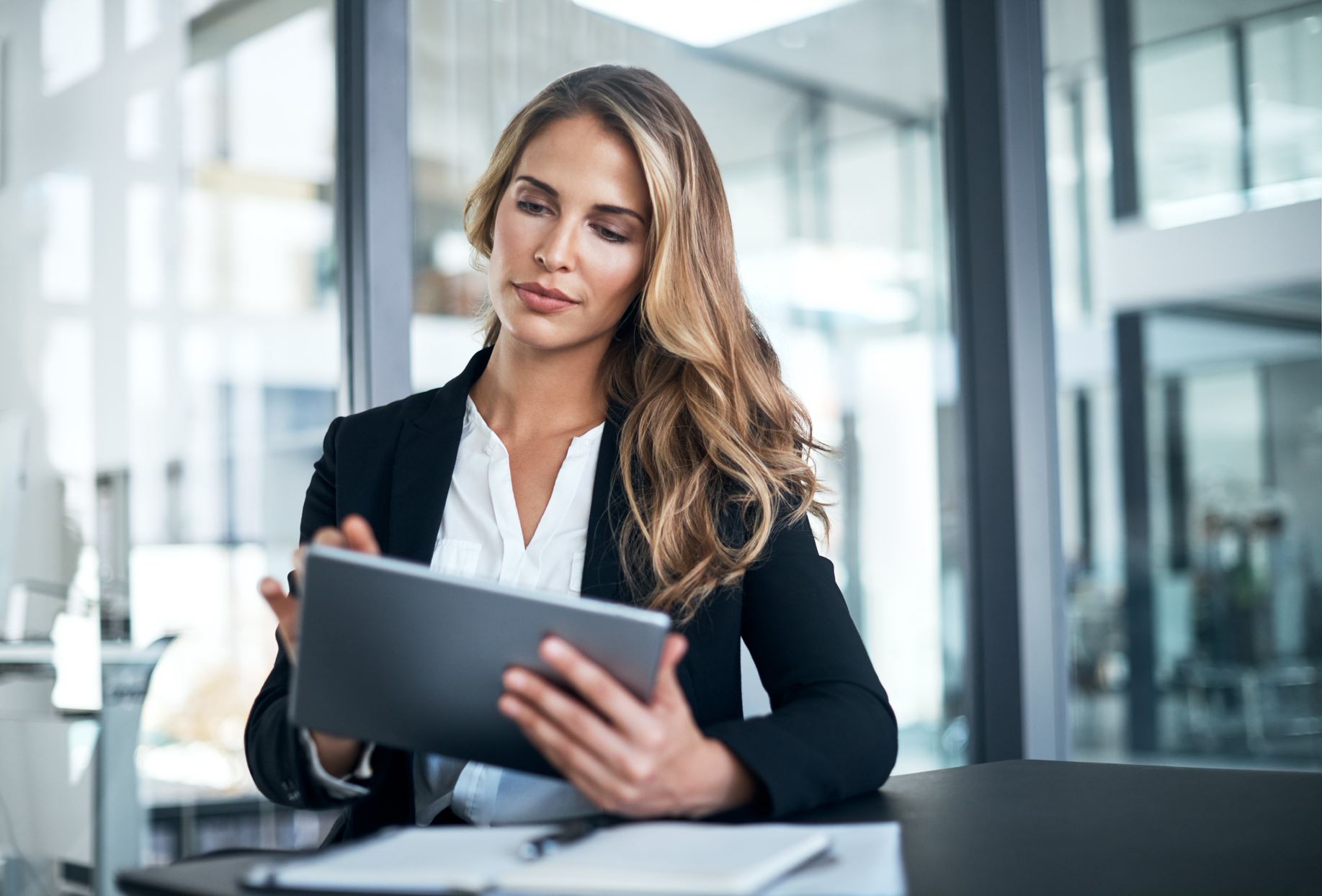 woman in suits working on a tablet in the office