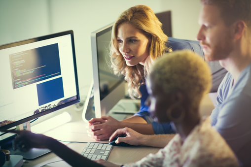 three people looking at the computer screen