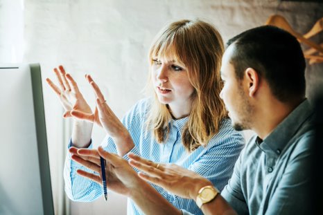 two people talking while looking at the screen