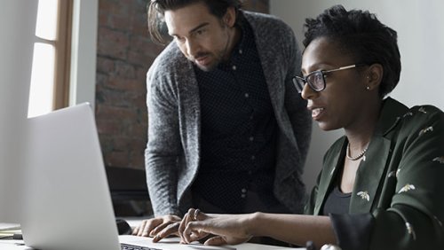 Woman working on a computer and a man next to her