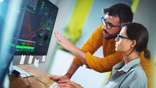 Man showing something at the monitor to the woman next to him