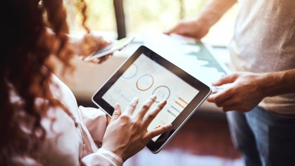 woman looking at graphs on tablet